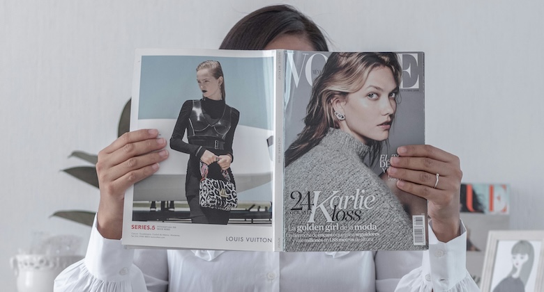 雑誌で芸能人ニュースをチェックする女性の画像